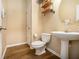 Convenient half bathroom with a pedestal sink, toilet, and minimal decor for a clean look at 5925 Crescent Landing Dr, Cumming, GA 30028