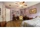 Charming bedroom featuring a ceiling fan, wood floors, and decorative art for a cozy retreat at 5925 Crescent Landing Dr, Cumming, GA 30028