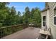 A wood deck is surrounded by trees, has a table and chair set and provides ample outdoor living space at 5925 Crescent Landing Dr, Cumming, GA 30028