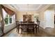 Formal dining room with tray ceiling, chandelier, and ample natural light from large windows at 5925 Crescent Landing Dr, Cumming, GA 30028