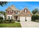 Charming brick home with manicured lawn, two-car garage, and lovely tree lined street at 5925 Crescent Landing Dr, Cumming, GA 30028