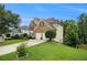 Well-maintained home with lush green lawn and mature trees, showcasing its curb appeal at 5925 Crescent Landing Dr, Cumming, GA 30028