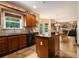 Well-lit kitchen featuring an island with seating, wooden cabinets, and a view to the living room at 5925 Crescent Landing Dr, Cumming, GA 30028