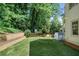 Landscaped backyard features a manicured lawn, retaining wall, and a charming storage shed at 968 Dean Nw Dr, Atlanta, GA 30318