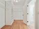 Walk-in closet with custom shelving, hardwood floors, and a view to the bathroom at 968 Dean Nw Dr, Atlanta, GA 30318