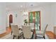 Elegant dining room with modern chandelier, glass table, and French doors at 968 Dean Nw Dr, Atlanta, GA 30318