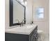Bathroom featuring a white countertop with sink, a large mirror and a window at 1337 M L King Jr Nw Dr, Atlanta, GA 30314