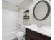 Well-lit bathroom showcasing a vanity, toilet, shelving, tub, and shower combination at 3235 Harms Way, Snellville, GA 30039