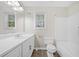 Bright bathroom with a double-sized vanity, a toilet, and a tub-shower combination under a window at 3235 Harms Way, Snellville, GA 30039
