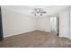A bedroom featuring wood-look floors, ceiling fan with lighting, and access to ensuite bath and walk-in closet at 3235 Harms Way, Snellville, GA 30039