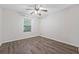 This bedroom boasts wood-look flooring, a ceiling fan with lighting, and a window that provides natural light at 3235 Harms Way, Snellville, GA 30039