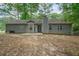 Back exterior of gray house, with a small patio and green trees surrounding at 3235 Harms Way, Snellville, GA 30039