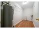 Bright laundry room with wood floors, a metal shelf, and a grey water heater at 3235 Harms Way, Snellville, GA 30039
