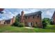 Spacious brick home featuring a large backyard, lush green lawn, mature trees, and patio at 571 Cold Water Ln, Mcdonough, GA 30252