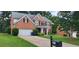 Charming two-story brick home featuring a well-manicured lawn, mature trees, and a two-car garage at 571 Cold Water Ln, Mcdonough, GA 30252