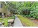 Backyard view features a stone walkway that leads into a landscaped yard with mature trees and greenery at 1640 Mount Mckinley Dr, Grayson, GA 30017