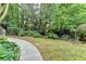 Lush backyard with manicured lawn, mature trees, and outdoor seating at 1640 Mount Mckinley Dr, Grayson, GA 30017
