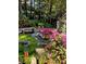 Landscaped backyard with a rock water feature, bench, and lush plantings at 1640 Mount Mckinley Dr, Grayson, GA 30017
