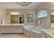 Luxurious bathroom featuring dual sinks, jacuzzi bathtub and patterned wallpaper at 1640 Mount Mckinley Dr, Grayson, GA 30017