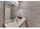 Cozy half-bathroom with wallpaper, vanity, and a decorative mirror at 1640 Mount Mckinley Dr, Grayson, GA 30017