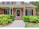 Inviting front porch with black door, brick and beautiful landscaping at 1640 Mount Mckinley Dr, Grayson, GA 30017