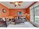 Cozy living room with a ceiling fan, leather furniture, and natural light from a large window at 1640 Mount Mckinley Dr, Grayson, GA 30017