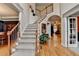 Elegant staircase with hardwood floors, carpeted steps, and adjacent dining room at 1640 Mount Mckinley Dr, Grayson, GA 30017