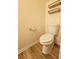 Toilet in a half-bathroom with modern shelves and wood-style floors at 2131 Meadow Peak Rd, Duluth, GA 30097
