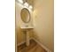 Elegant powder room with pedestal sink, oval mirror, and modern lighting fixture at 2131 Meadow Peak Rd, Duluth, GA 30097