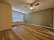 Bedroom with wood floors, a ceiling fan, and a large window providing natural light at 2131 Meadow Peak Rd, Duluth, GA 30097