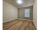 Neutral bedroom featuring wood look floors, a large window that provides ample natural light, and neutral paint at 2131 Meadow Peak Rd, Duluth, GA 30097