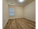 Neutral bedroom featuring wood look floors, a large window that provides ample natural light, and neutral paint at 2131 Meadow Peak Rd, Duluth, GA 30097