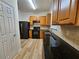 Traditional kitchen with black appliances, granite countertops, and light wood cabinets at 2131 Meadow Peak Rd, Duluth, GA 30097