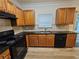 Well-equipped kitchen featuring granite countertops, black appliances, and wood cabinetry at 2131 Meadow Peak Rd, Duluth, GA 30097