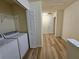 Bright laundry room with washer, dryer, wood look floors, closet and wire rack shelving for organized storage at 2131 Meadow Peak Rd, Duluth, GA 30097