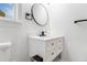 Well-lit bathroom with a modern vanity, round mirror, and a sleek black faucet at 2608 Argo Drive Southeast Se Dr, Smyrna, GA 30080