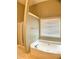 Bright bathroom featuring a soaking tub beneath a window, complemented by a glass-enclosed shower at 518 Oriole Farm Trl, Canton, GA 30114