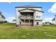 Wide backyard with lush green grass and a covered porch on the two-story house at 1494 Weeping Tree Cir, Auburn, GA 30548