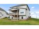View of a backyard with healthy green grass leading up to the home and covered porch at 1494 Weeping Tree Cir, Auburn, GA 30548