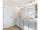 Bathroom with double sinks, gray cabinets, white countertop, and tile floor at 1494 Weeping Tree Cir, Auburn, GA 30548