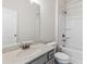 Bathroom featuring a vanity with granite countertop, a commode, and a tub with shower at 1494 Weeping Tree Cir, Auburn, GA 30548