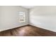 A bedroom featuring hardwood floors, white walls, and a window that offers natural light at 1494 Weeping Tree Cir, Auburn, GA 30548