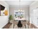 Charming breakfast nook features a marble table set for four, complemented by an elegant chandelier and natural light at 1494 Weeping Tree Cir, Auburn, GA 30548