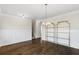 Open dining space with hardwood flooring, elegant lighting, and classic wainscoting offers flexible living space at 1494 Weeping Tree Cir, Auburn, GA 30548