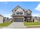 Beautiful two-story home featuring a brick and gray siding exterior with an attached two-car garage and a well-maintained lawn at 1494 Weeping Tree Cir, Auburn, GA 30548