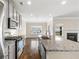 Kitchen area with stainless steel appliances and an island that flows into the living room with fireplace at 1494 Weeping Tree Cir, Auburn, GA 30548