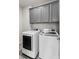 Laundry room with gray cabinets above brand new washer and dryer units at 1494 Weeping Tree Cir, Auburn, GA 30548