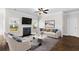 Bright living room with a fireplace, large windows, hardwood floors, and comfortable seating for relaxing and entertaining guests at 1494 Weeping Tree Cir, Auburn, GA 30548