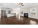 Open living room featuring a fireplace and hardwood floors that flows into the kitchen area with stainless steel appliances at 1494 Weeping Tree Cir, Auburn, GA 30548