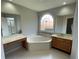 A luxurious bathroom with a soaking tub, vanity, and large window that provides natural light at 7123 Woodridge Ln, Union City, GA 30291